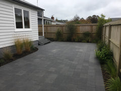 Completed grey paver patio with native grasses and timber fencing