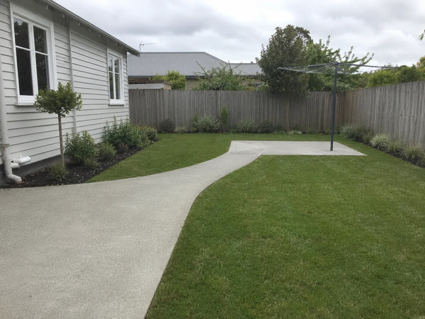 Light-grey concrete garden path leading to a clothesline pad in a Christchurch backyard