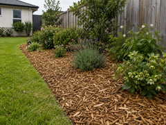 Natural golden-brown Eco mulch spread around flowering plants and shrubs