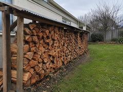 Seasoned Oregon firewood stacked beneath a practical backyard lean-to