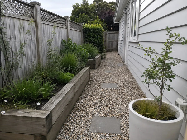 Pea gravel path with stepping pavers beside raised timber garden beds